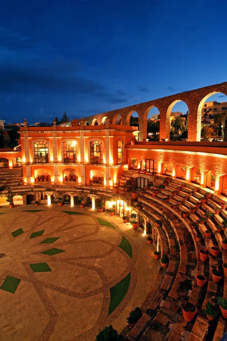 Stone arena courtyard and aqueduct at blue hour